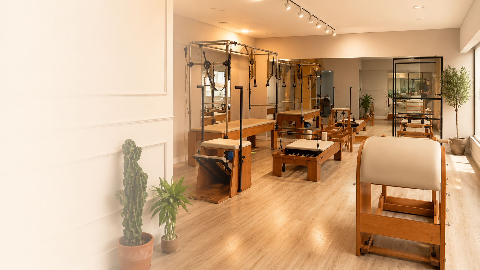 Sala ampla e iluminada do Ares Studio com aparelhos de Pilates