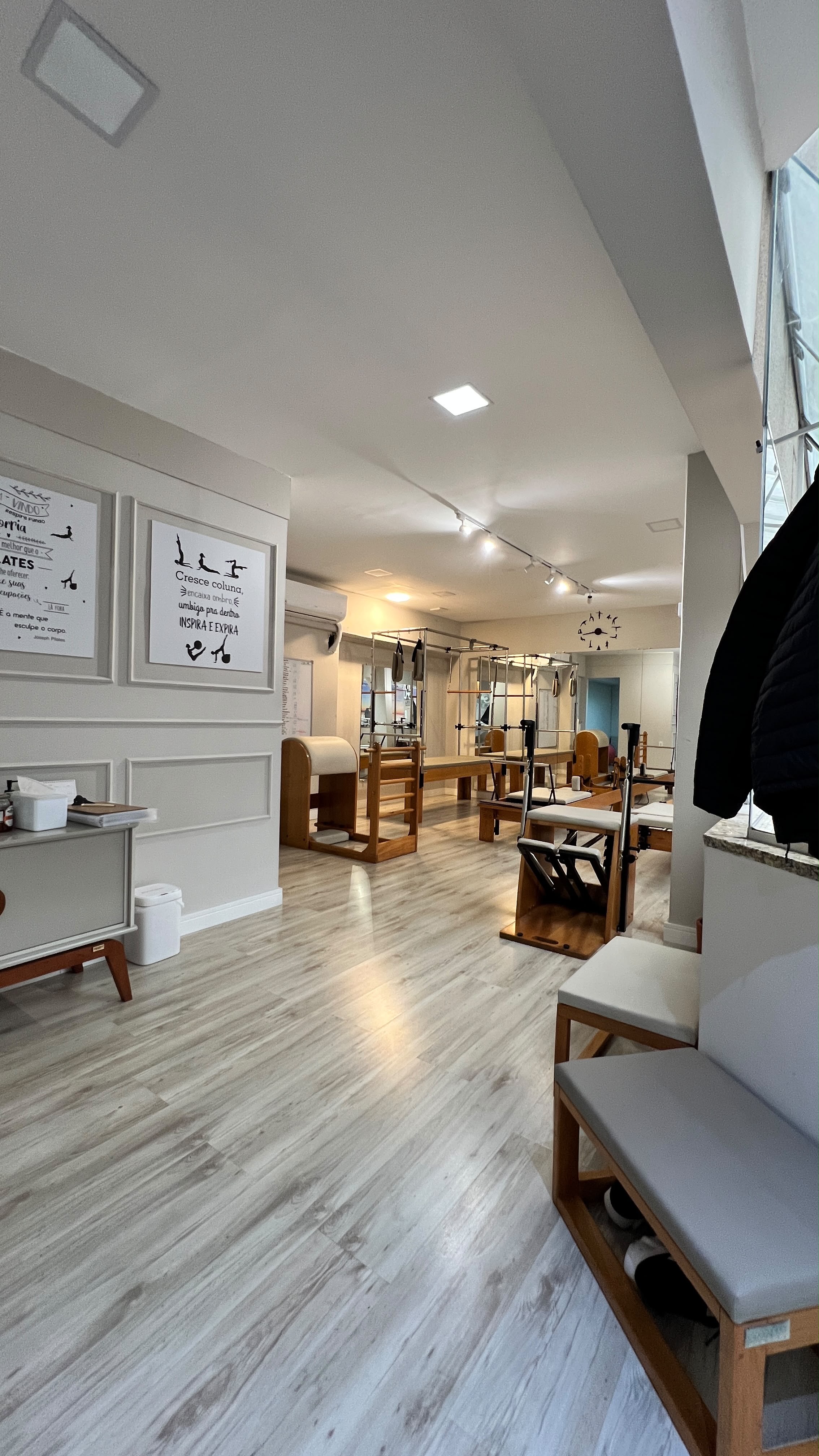 Sala do Ares Studio com aparelhos de Pilates e área de espera