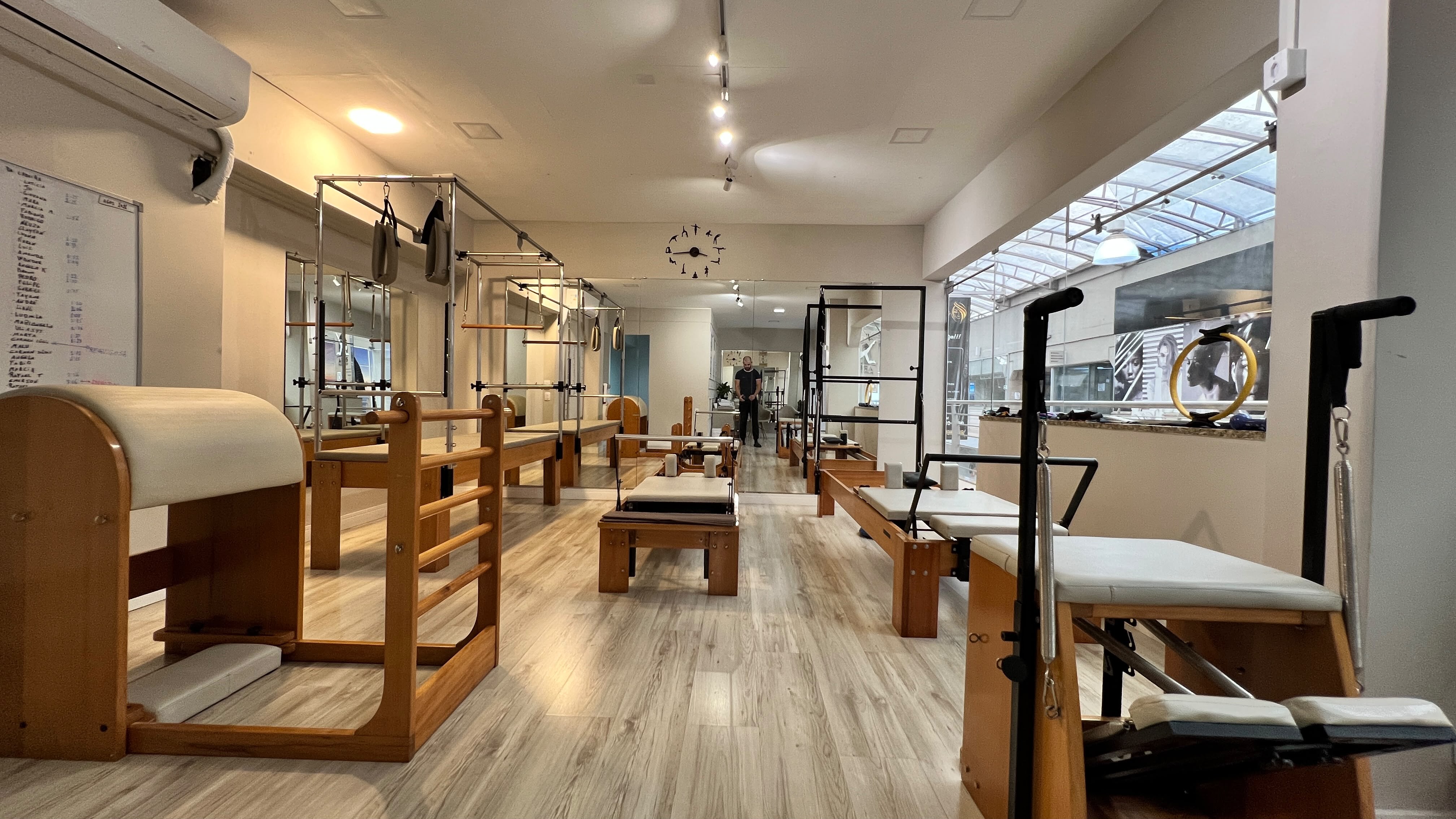 Ambiente do Ares Studio com quadros, recepção e equipamentos de Pilates
